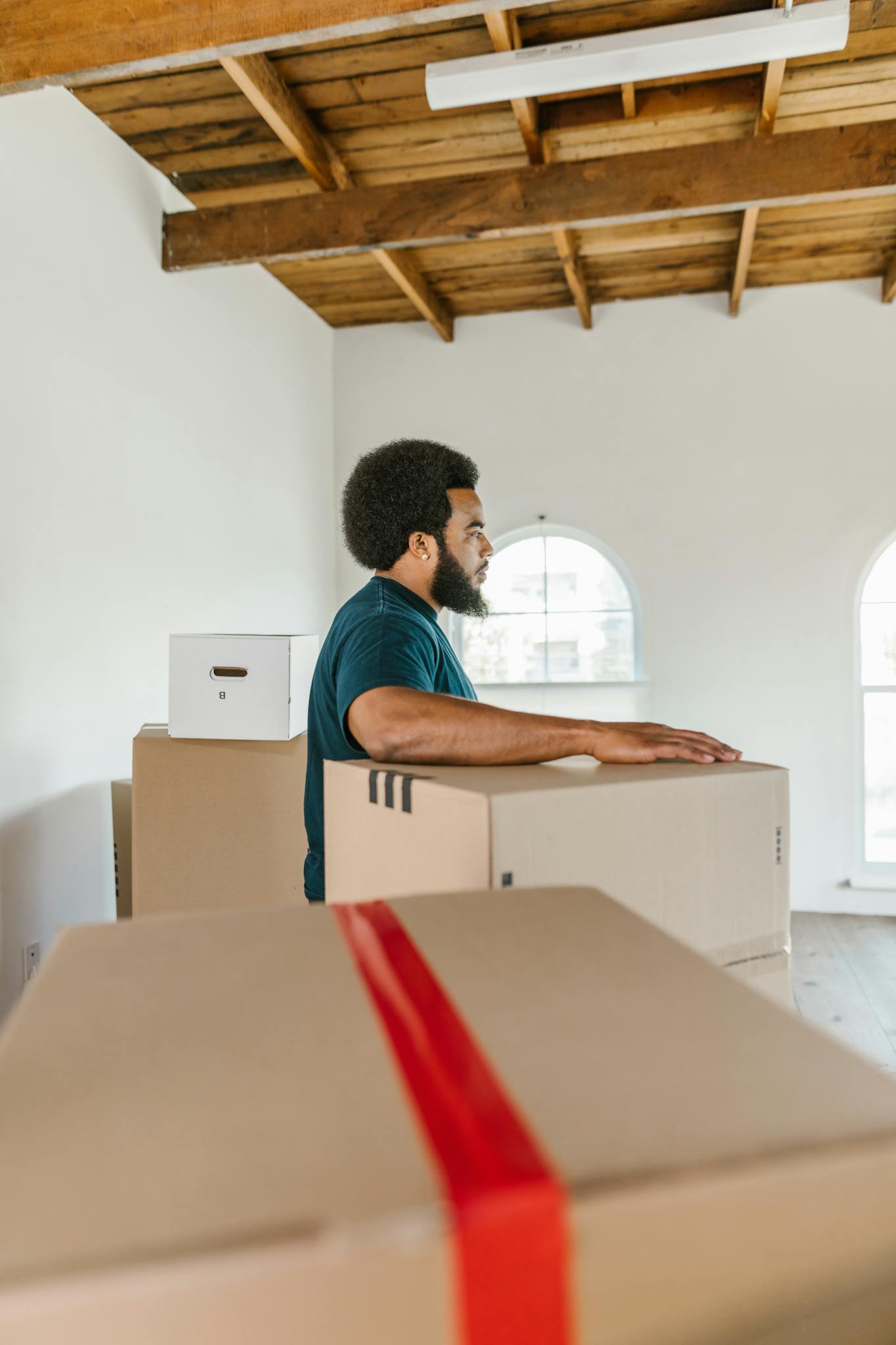 man handling moving boxes in a spacious AdamHelper man handling moving boxes in a spacious