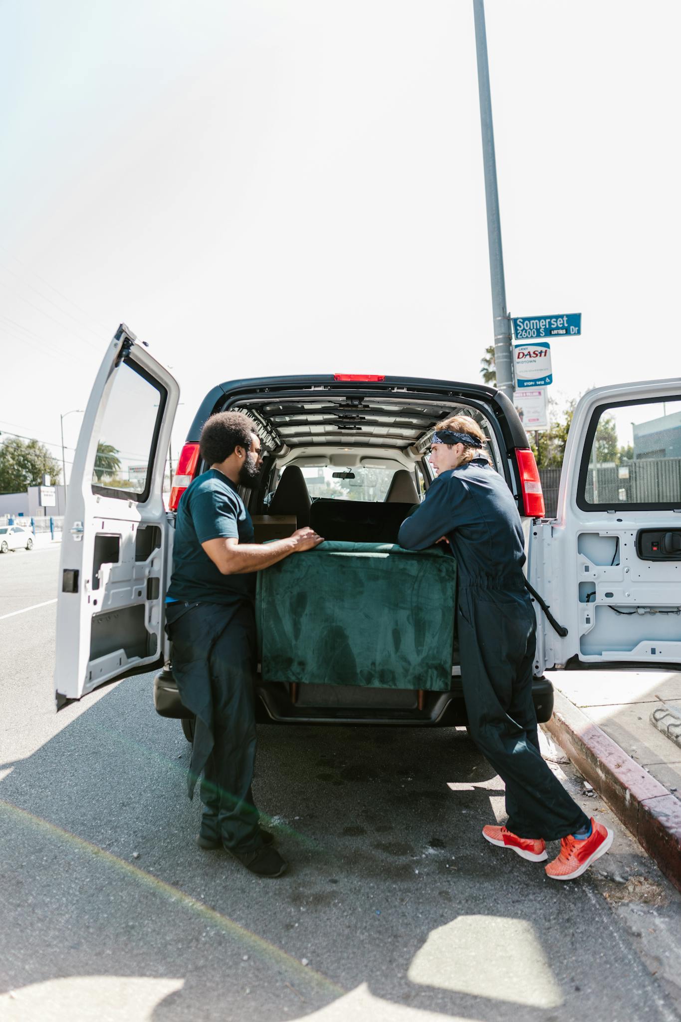 two movers load a van with furniture AdamHelper two movers load a van with furniture